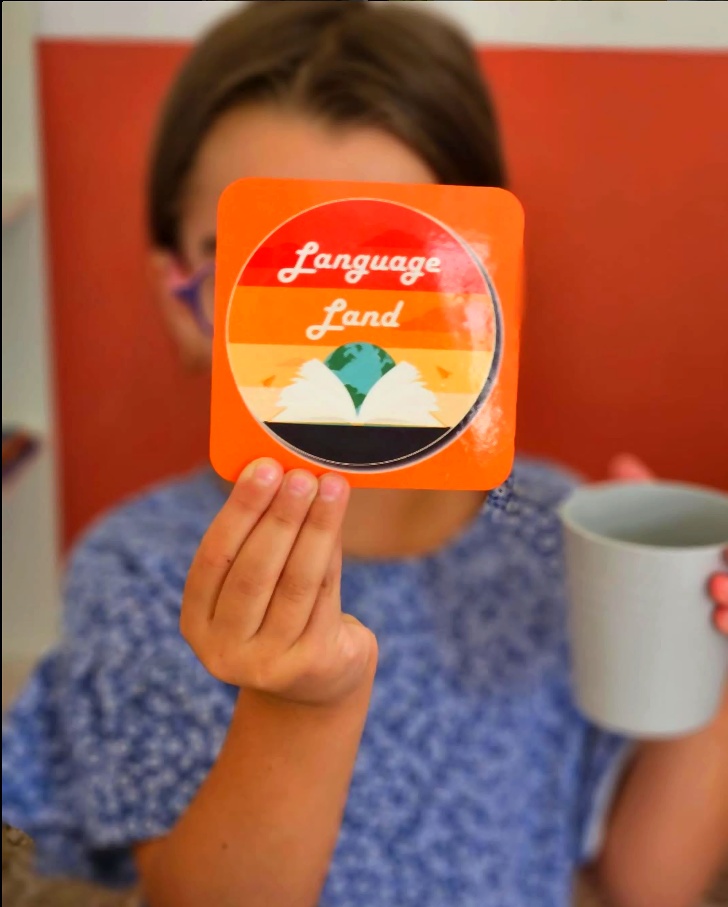 Student holding Language Land sticker